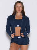 front profile view of a model wearing the Cloud Full Length Jacket in Sapphire Blue color paired with the matching shorts 
