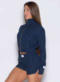 left side profile view of a model wearing the Cloud Full Length Jacket in Sapphire Blue color