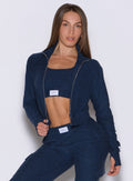 front profile view of a model wearing the Cloud Full Length Jacket in Sapphire Blue color