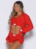 front left side profile view of a model wearing the Cloud Full Length Jacket in scarlet red color