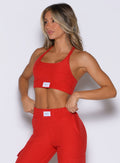 front profile view of a model with both hands on her waist wearing the Cloud Lounge Bra in scarlet red color