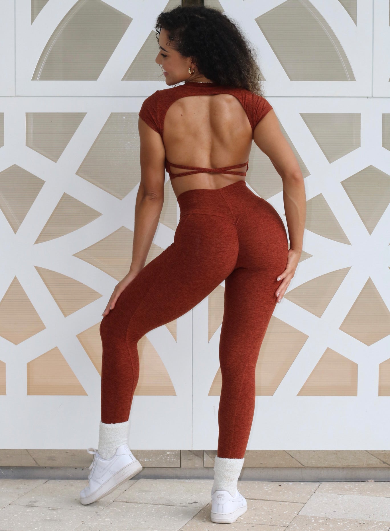 Back profile view of a model in our cloud leggings in Cinnamon color and a matching open back bra