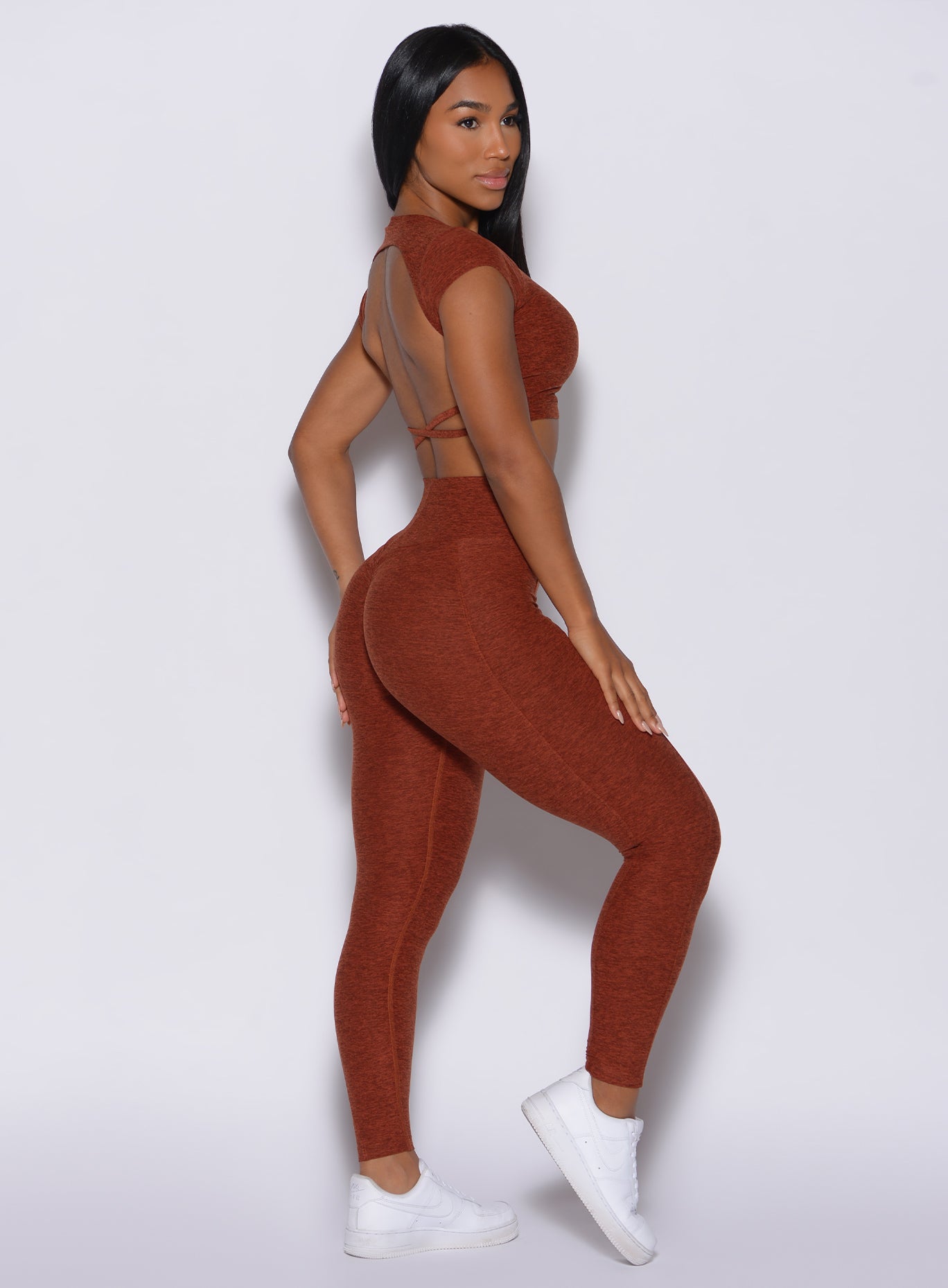Right side profile view of a model in our cloud leggings in Cinnamon color and a matching  sports bra