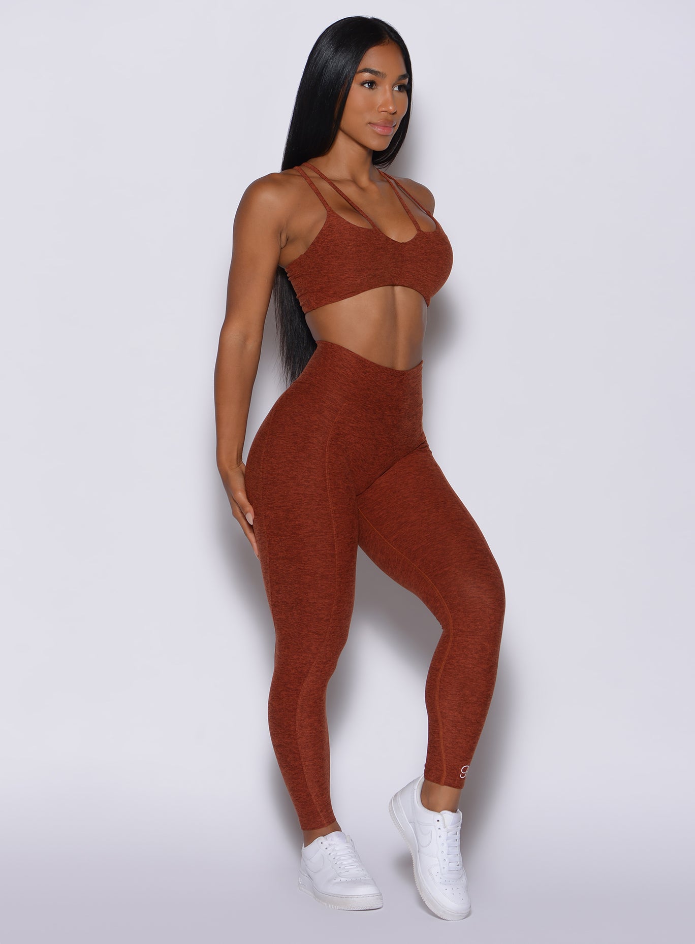 Right side profile view of a model in our cloud leggings in Cinnamon color and a matching bra 