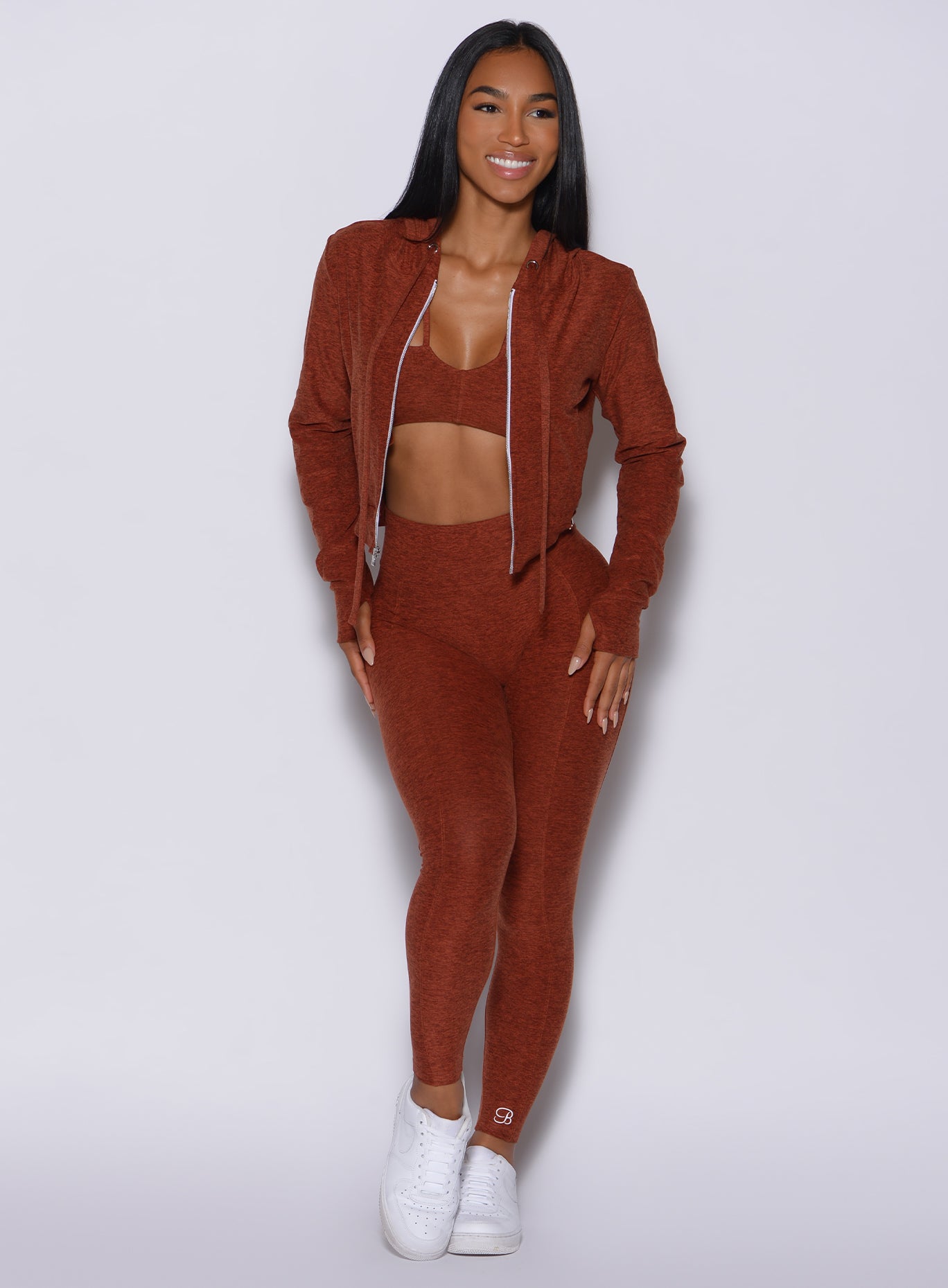 Front profile view of a model in our cloud leggings in Cinnamon color along with a matching bra and jacket