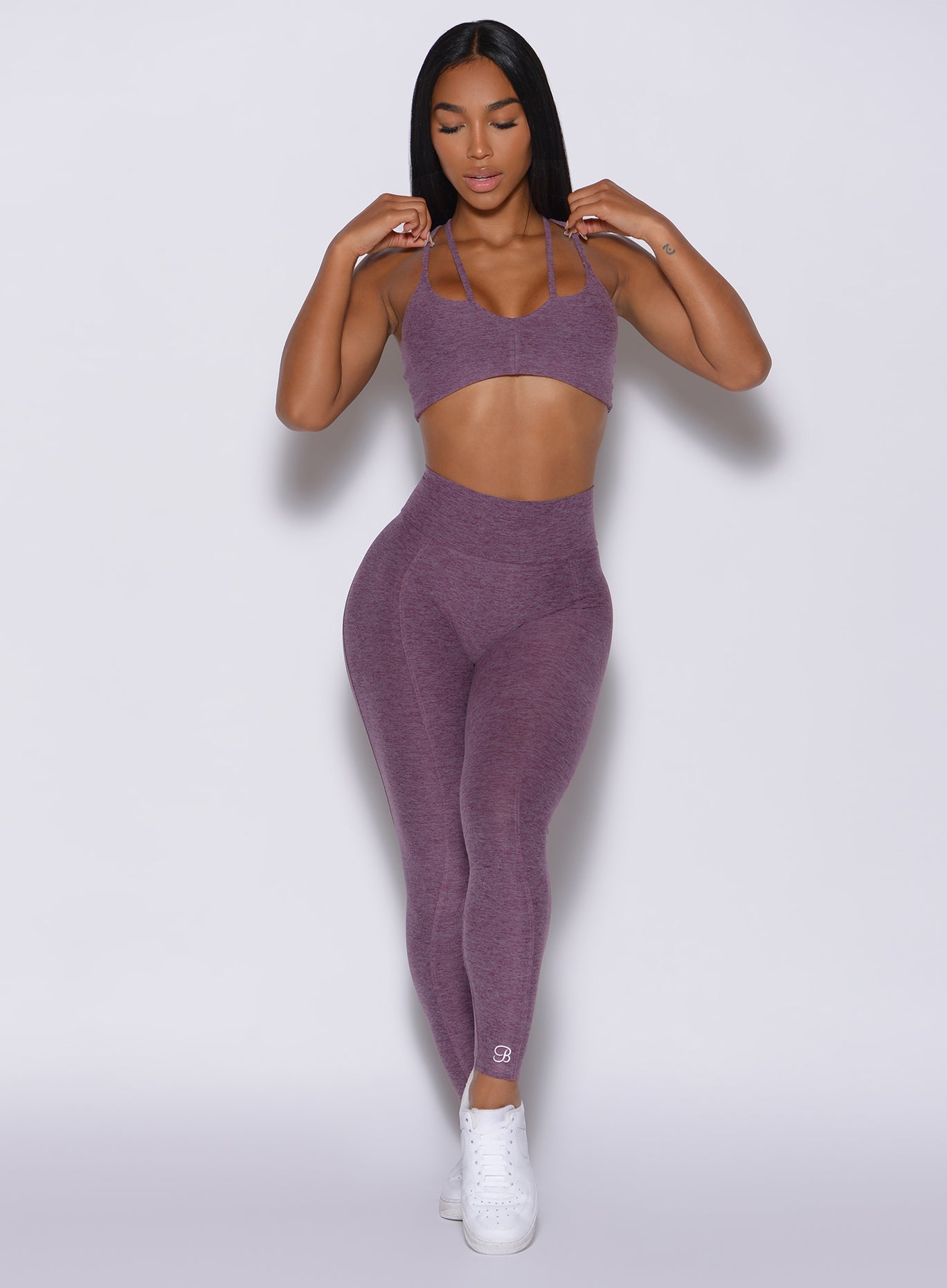 Front profile view of a model in our cloud leggings in  regal purple color and a  matching sports bra 