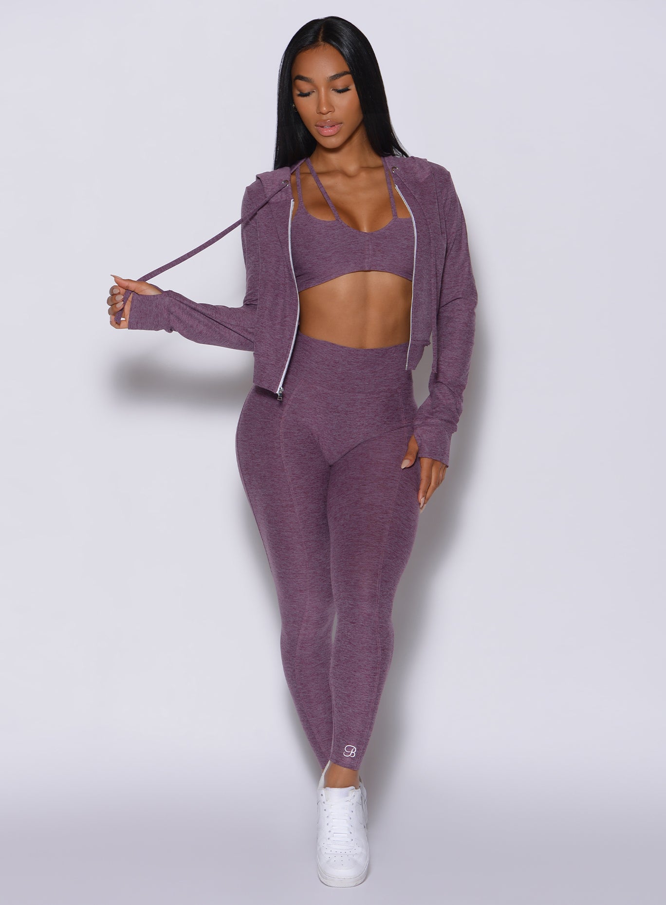 Front profile view of a model in our cloud leggings in Regal Purple along with the matching bra and jacket 