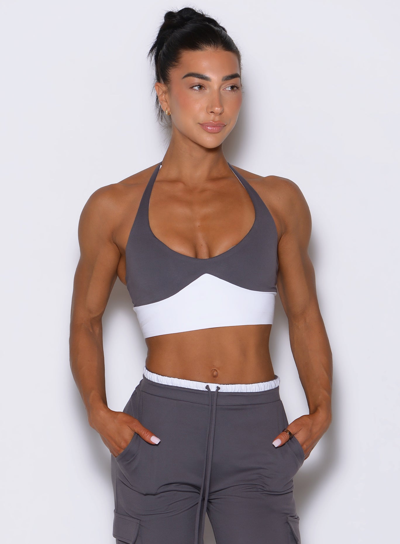 Front view of model looking left wearing Bombshell Sportswear Confidence bra top in Champion Grey color, featuring sculpting supportive fit and cleavage-enhancing front