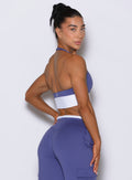 Back right side profile view of model looking over shoulder wearing Bombshell Sportswear Confidence bra top in Future Dusk color, featuring open back design and sculpting supportive fit