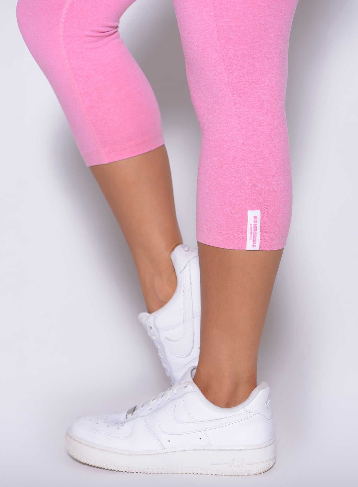 Close up of Bubblegum Contour Capri Leggings with the signature Bombshell Sportswear logo tag