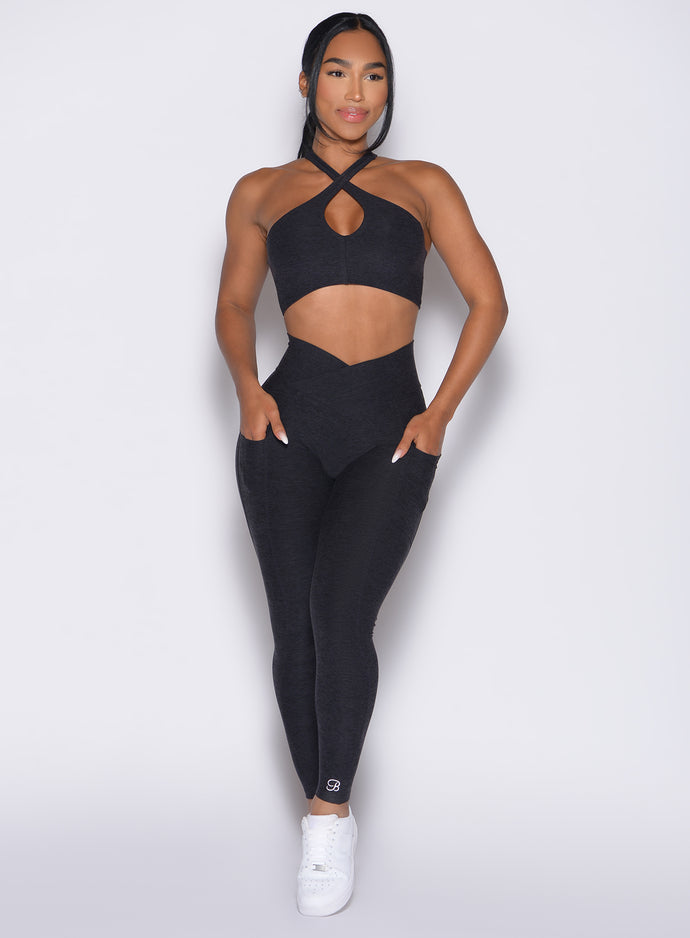 front profile view of a model wearing our Contour Leggings and the matching Cross Over Halter Bra in Heathered Black color