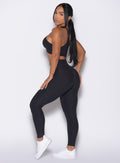 left side view of a model wearing our Contour Leggings and the matching Cross Over Halter Bra in Heathered Black color
