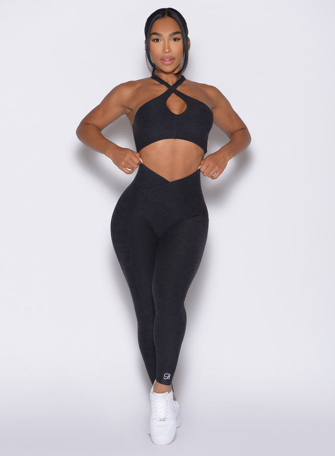 Model facing forward wearing our Contour Leggings and the matching Cross Over Halter Bra in Heathered Black color