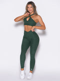 front profile view of a model wearing our Contour Leggings and the matching Cross Over Halter Bra in Pine color

