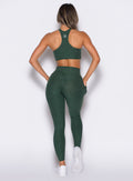 back profile of a model wearing the Contour Leggings and the matching Cross Over Halter Bra in Pine color
