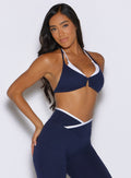 front right side view of a model wearing the Contrast Voltage Sports Bra in Navy color