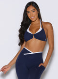 front profile view of a model with one hand in the side pocket of the leggings wearing the Contrast Voltage Sports Bra in Navy color