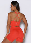 A rear view shot of the model wearing the Core Comfort Tank in Inferno color, paired with matching shorts.
