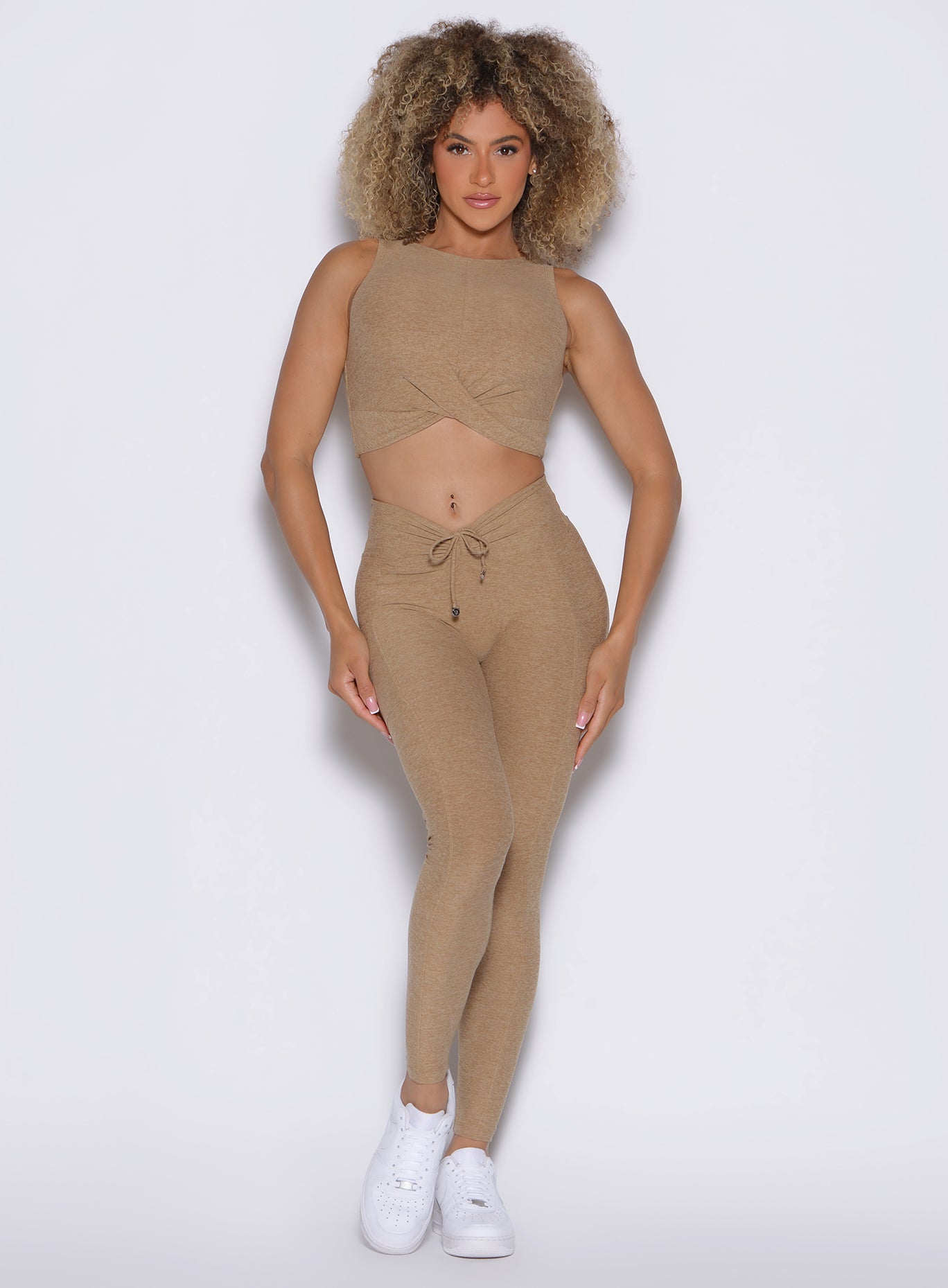 front profile view of a model wearing the Charm Fit Leggings in sandstone color