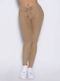 close up front view of a model wearing the Charm Fit Leggings in sandstone color