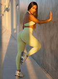 model in outdoors supporting herself with one hand on wall wearing the Charm Fit Leggings in serpentine color