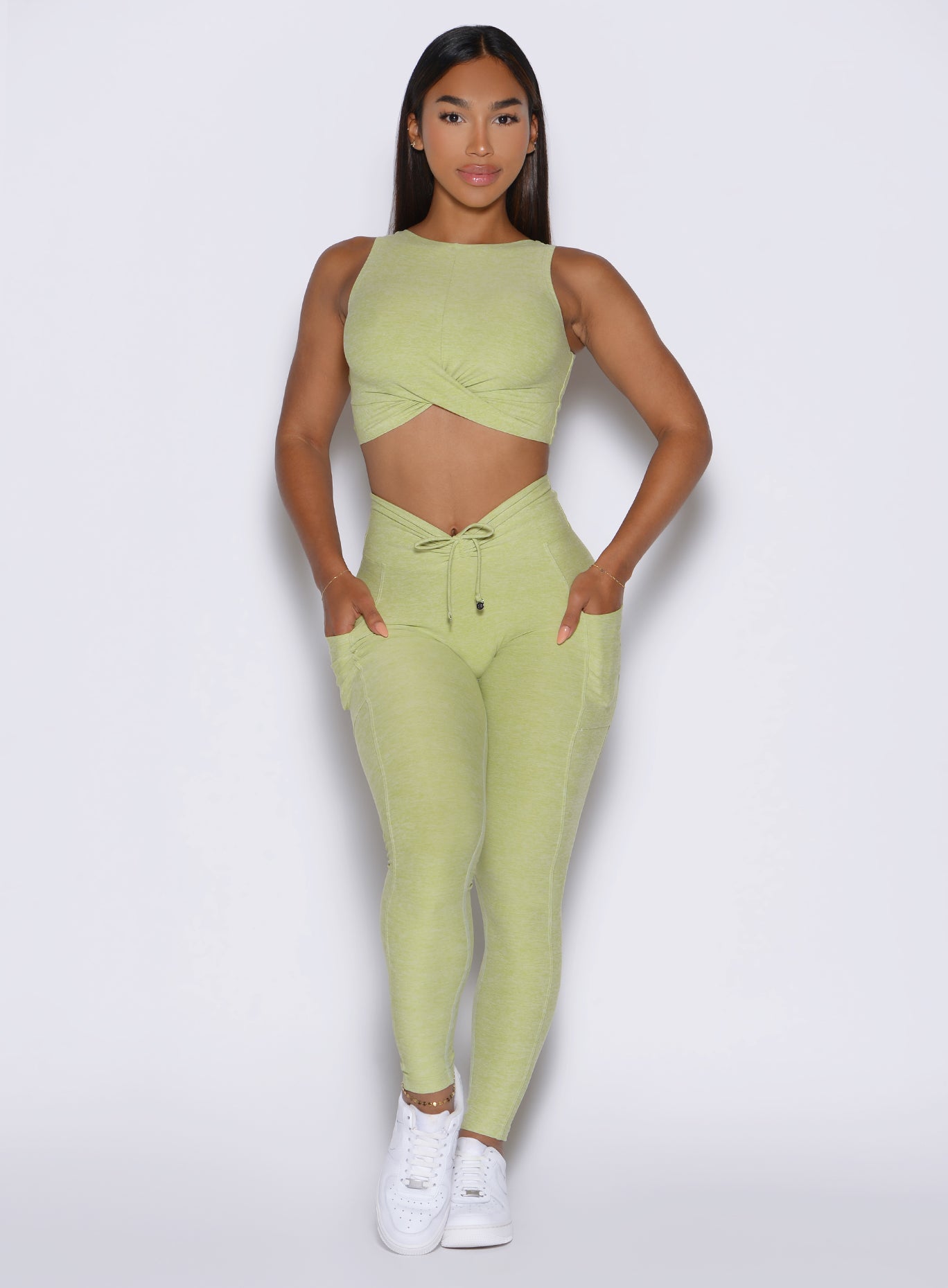 front view of a model wearing the Charm Fit Leggings in serpentine color paired with the matching top
