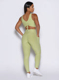 back profile view of a model facing to the right side wearing the Charm Fit Leggings in serpentine color
