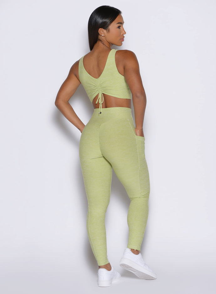 back profile view of a model facing to the right side wearing the Charm Fit Leggings in serpentine color