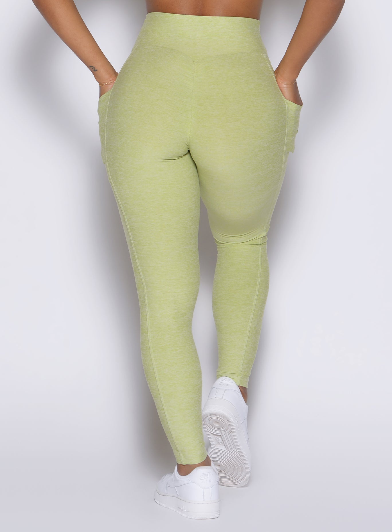 close up back profile view of a model wearing the Charm Fit Leggings in serpentine color