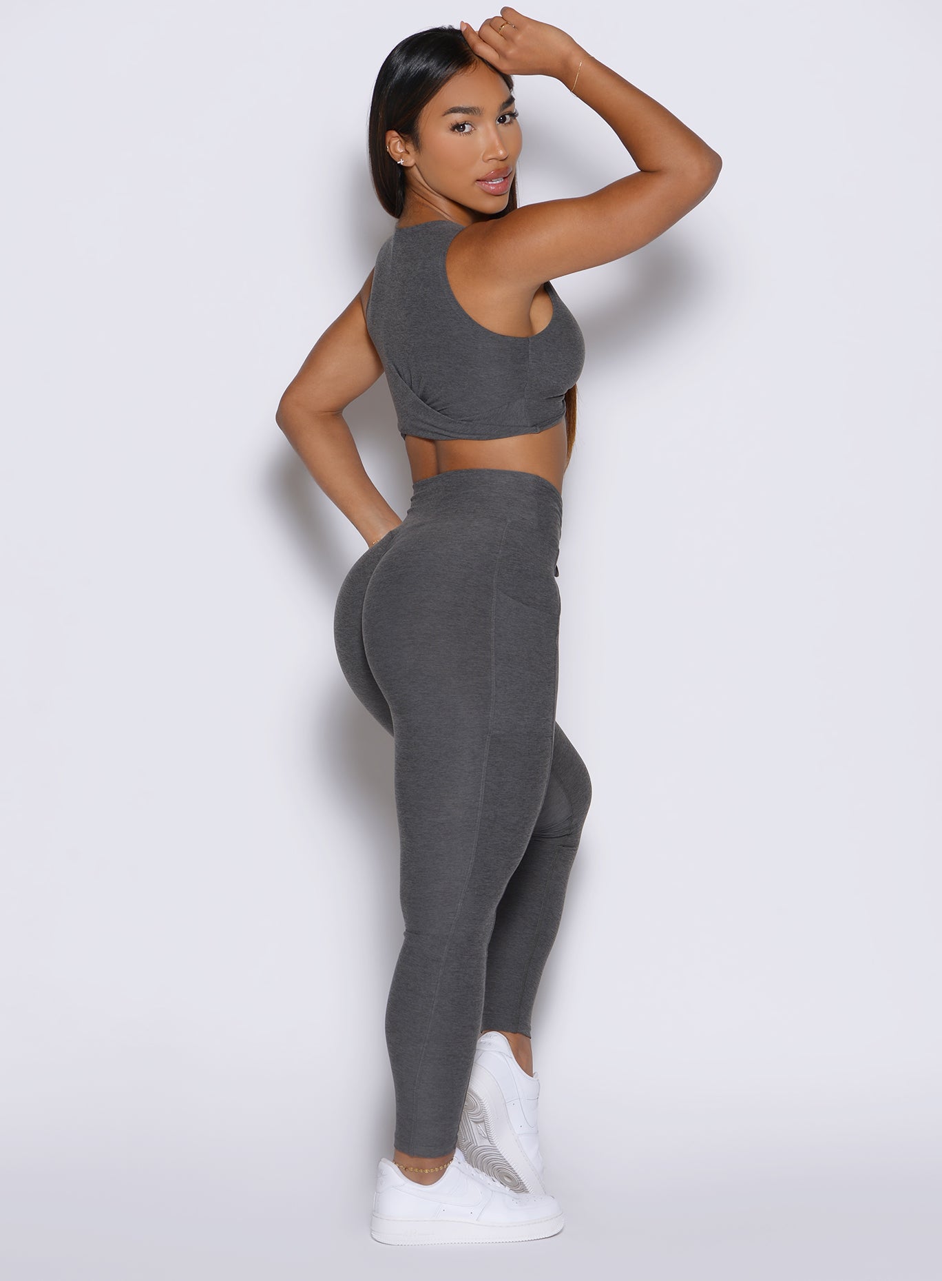 right side profile view of a model looking over her shoulder wearing the Charm Fit Leggings in Steel Shadow color
