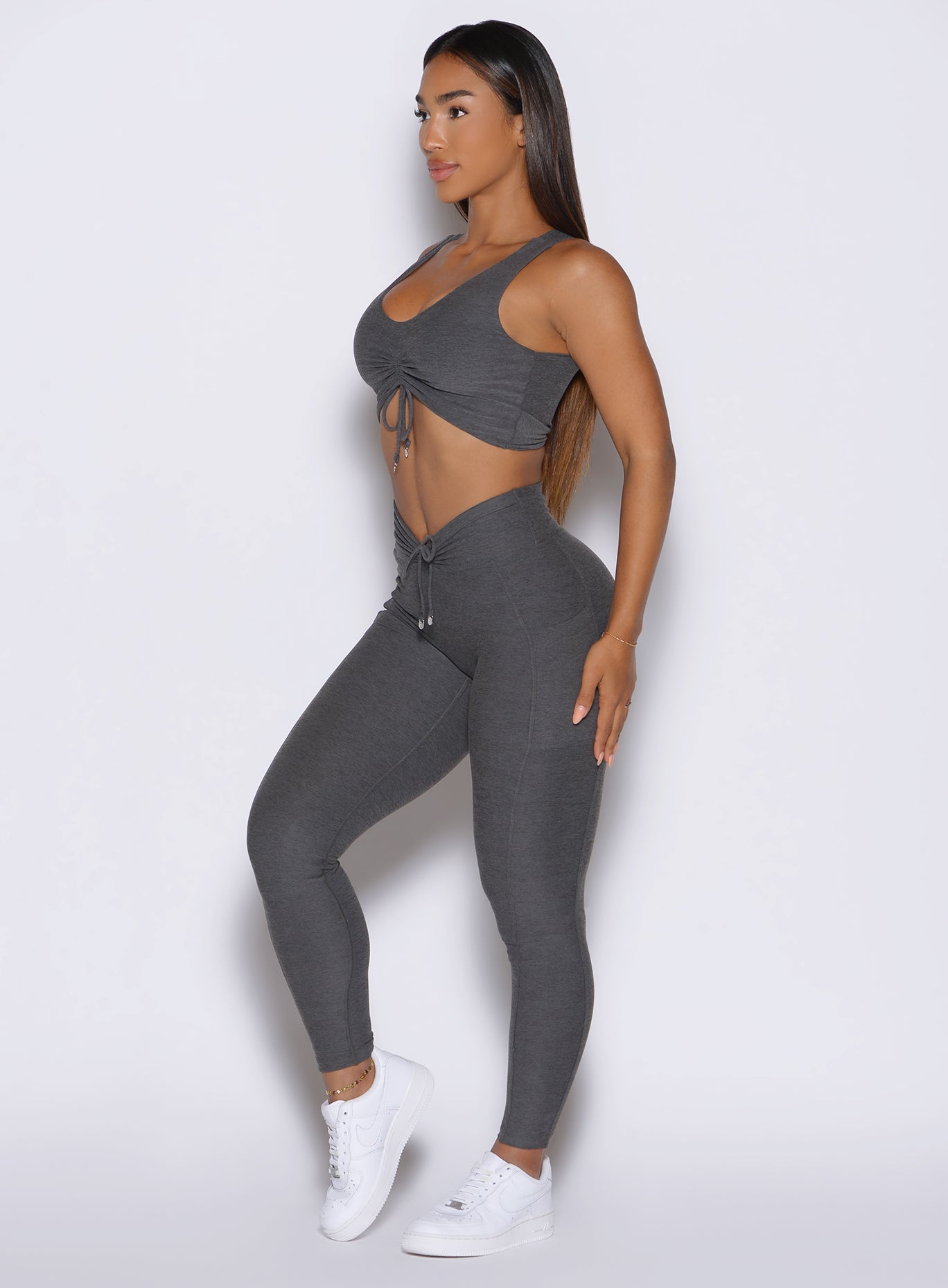 left side profile view of a model wearing the Charm Fit Leggings in Steel Shadow color