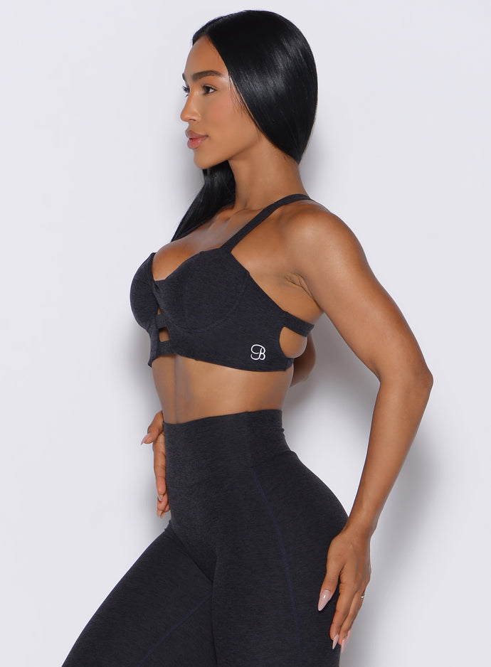left side profile view of a model wearing our core set bra in heather black color along with the matching leggings