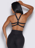 back view of a model wearing our core set bra in heather black color along with the matching leggings