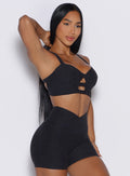 right profile view of a model holding her hair wearing our core set bra in heather black color along with the matching shorts