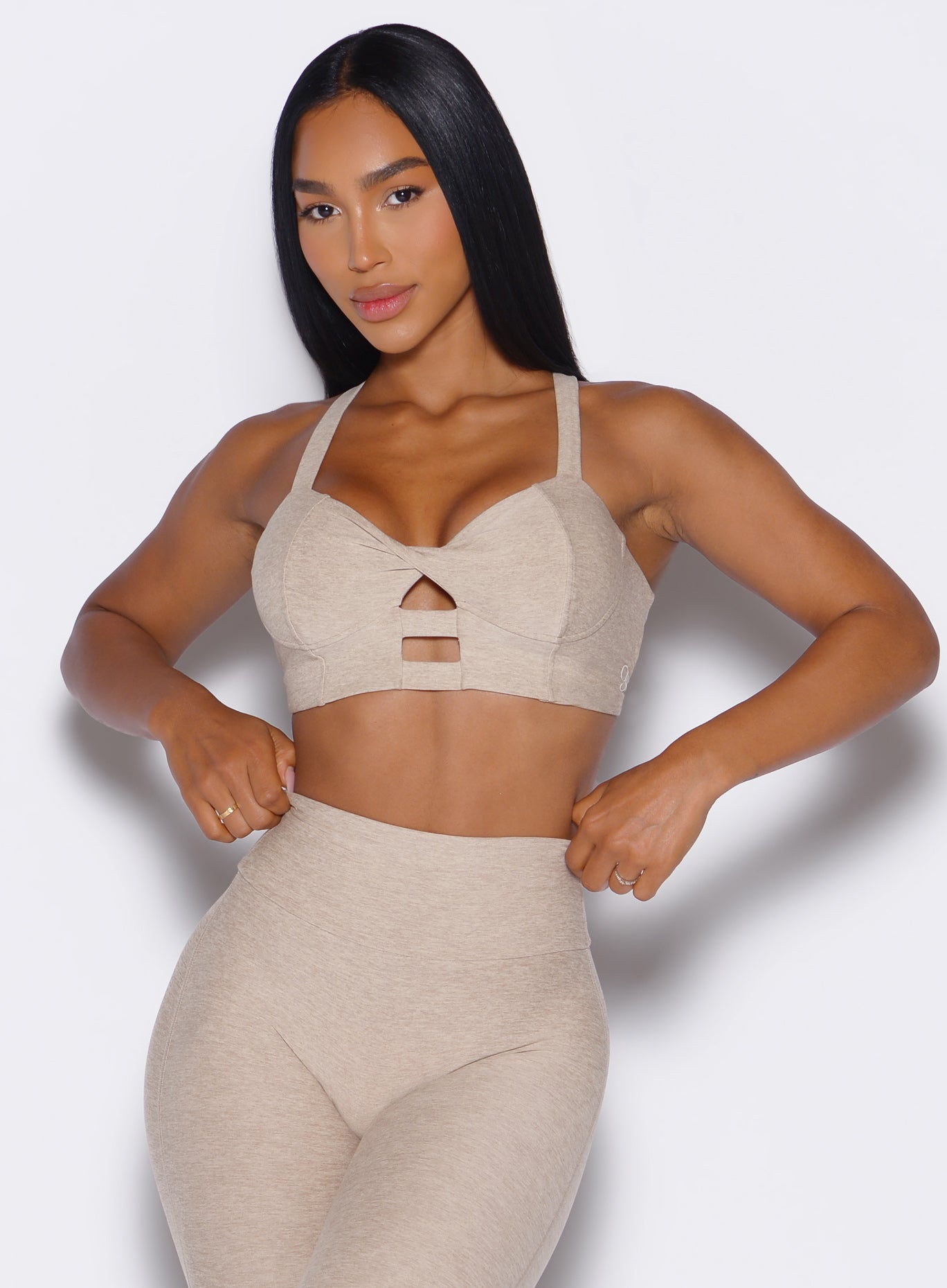 front profile view of a model wearing our core set bra in taupe color along with the matching Leggings