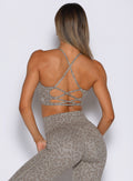 back profile view of a model wearing the Cross Fit Bra in Nori cheetah color