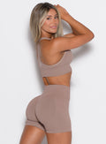 right side profile view of a model facing right wearing our cross over bra in soft mocha color along with the matching shorts