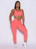 close up front view of a model wearing the Curvemax leggings in neon apricot pink color 