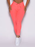 close up front view of a model wearing the Curvemax leggings in neon apricot pink color 