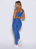 back left side profile view of a model wearing the Curvemax leggings in neon blue rave color 