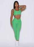 front profile view of a model wearing the Curvemax leggings in neon miami beach color 