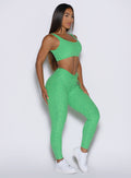 right side profile view of a model wearing the Curvemax leggings in neon miami beach color 