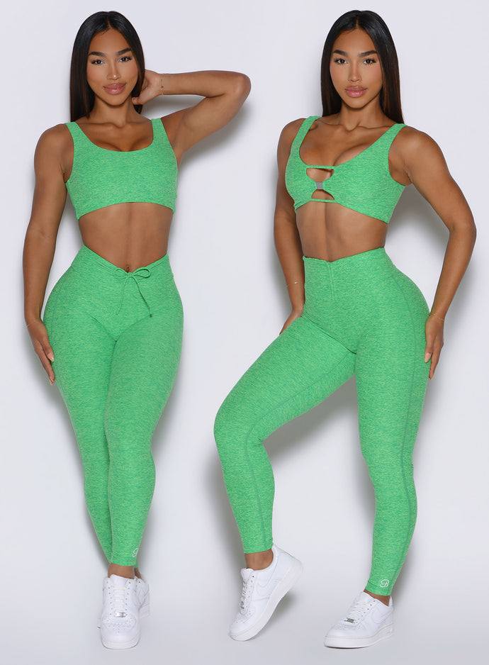 front profile view of a model showcasing the V cut and straight waistband side by side wearing the Curvemax leggings in neon miami beach color 