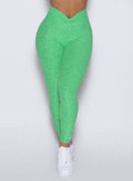 front profile view of a model showcasing the V cut waistband wearing the Curvemax leggings in neon miami beach color 