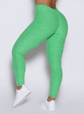 front profile view of a model showcasing the V cut waistband wearing the Curvemax leggings in neon miami beach color 