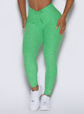 close up front view of a model showcasing the front ties wearing the Curvemax leggings in neon miami beach color 