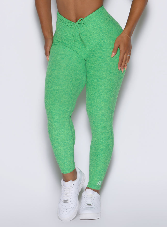 close up front view of a model showcasing the front ties wearing the Curvemax leggings in neon miami beach color 