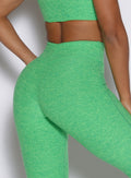 zoomed in back right side profile view of a model wearing the Curvemax leggings in neon miami beach color 