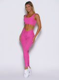 front left side profile view of a model wearing the Curvemax leggings in neon pink sorbet color