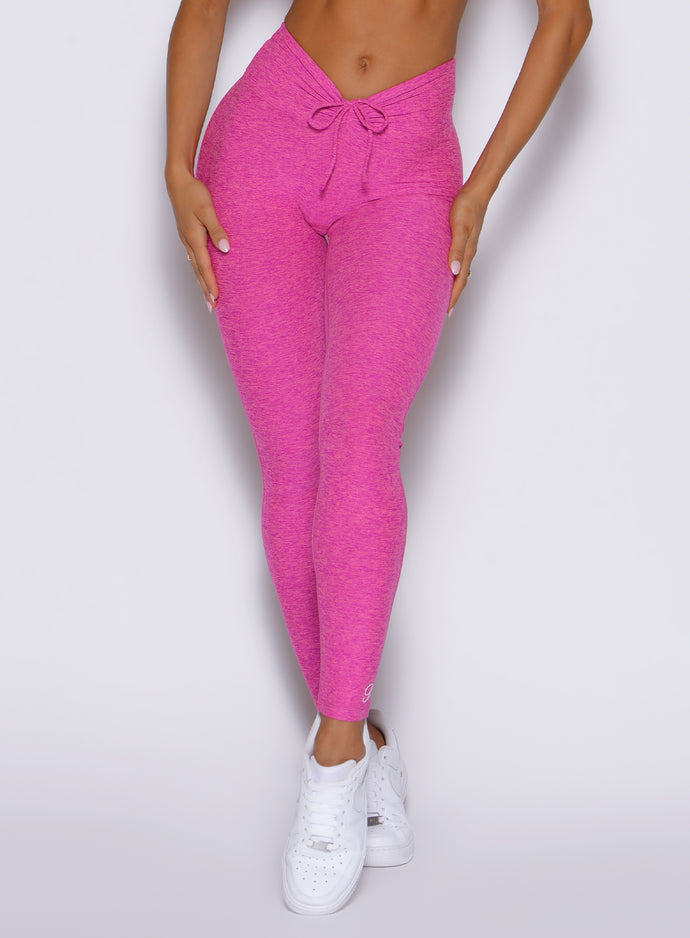 close up front view of a model showcasing the front ties wearing the Curvemax leggings in neon pink sorbet color